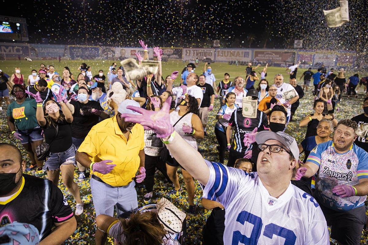 People scramble for money during the annual “$5,000 Cash Drop presented by Jarritos&#x20 ...