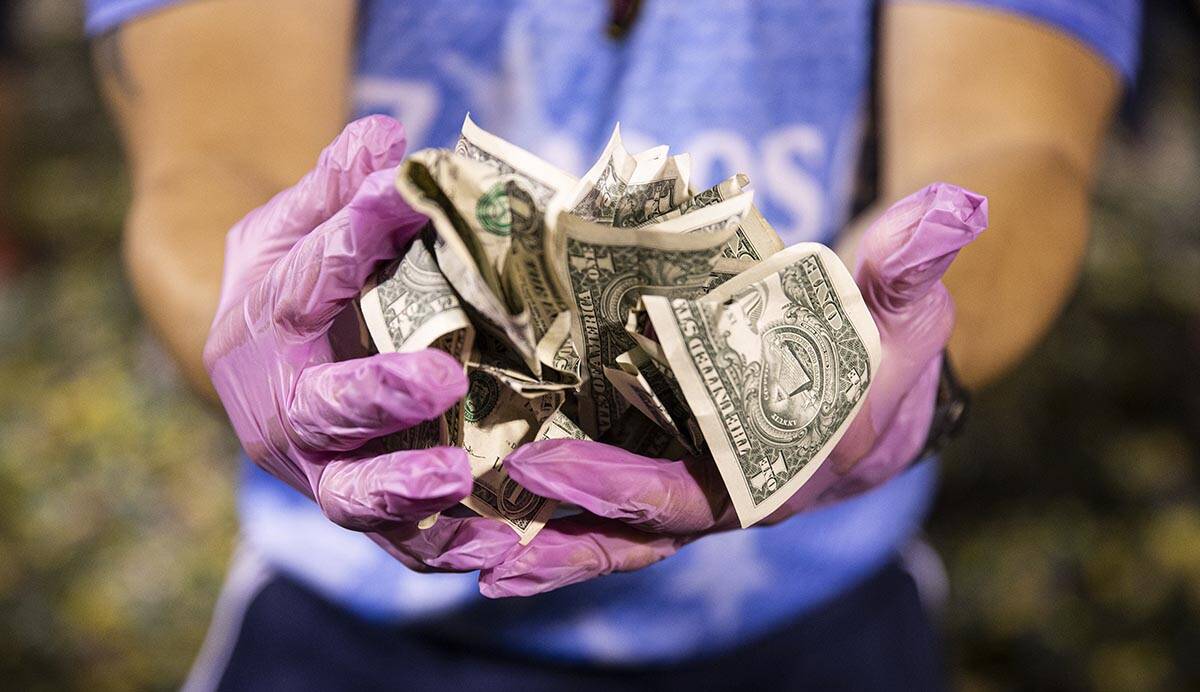 Fans show off the money they won during the annual “$5,000 Cash Drop presented by Jarrit ...