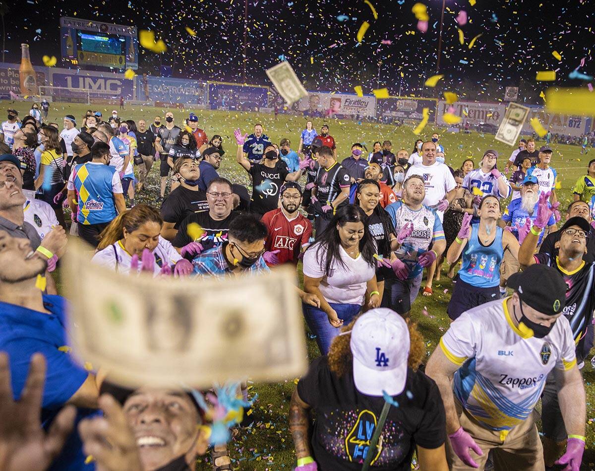 People scramble for money during the annual “$5,000 Cash Drop presented by Jarritos&#x20 ...