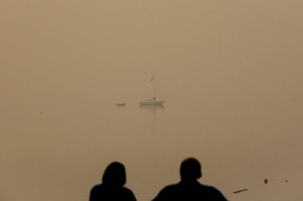 In this Friday, Aug. 27, 2021, file photo, a couple looks out on Lake Tahoe, which is blanketed ...