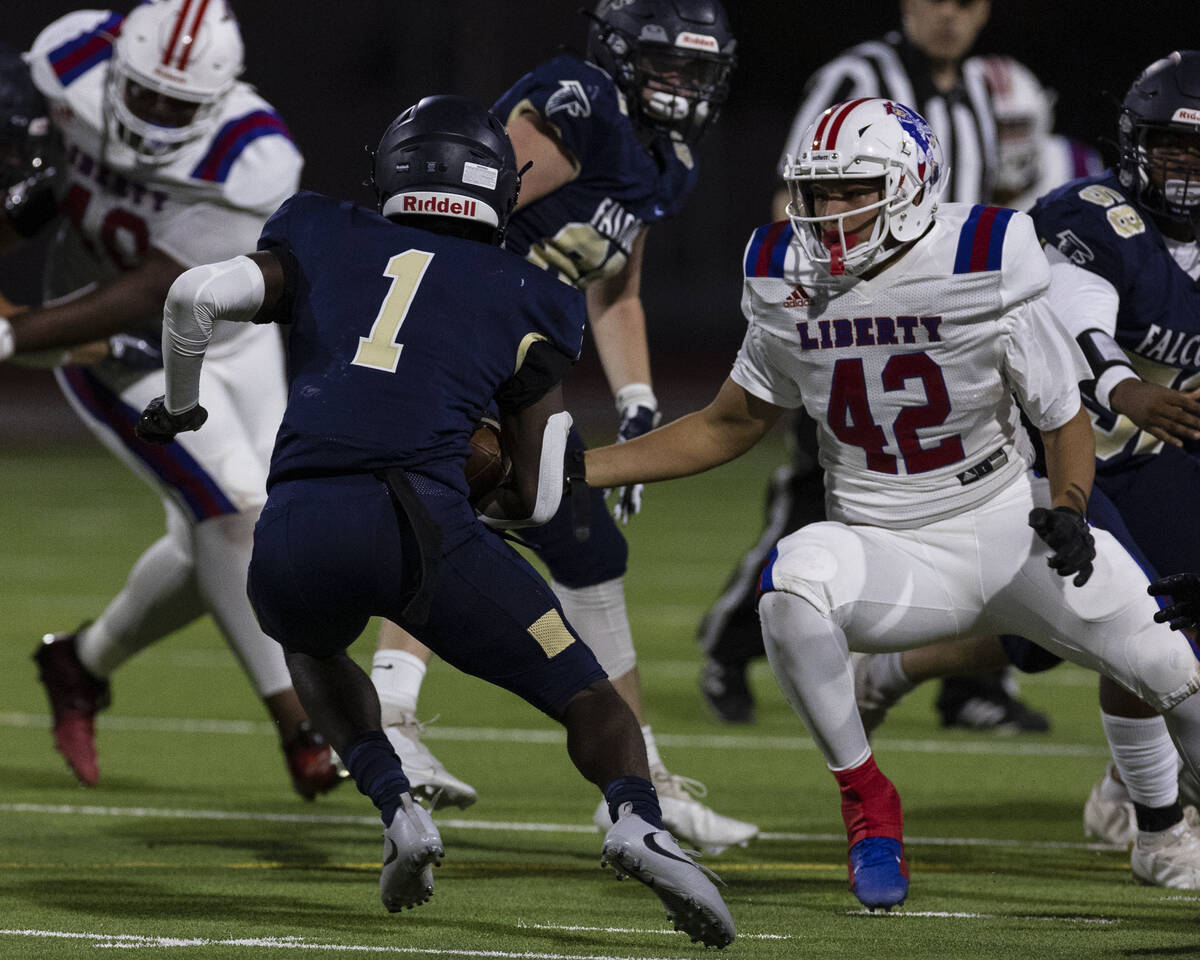 Foothill High running back Kendric Thomas (1) avoids a tackle from Liberty High defensive line ...
