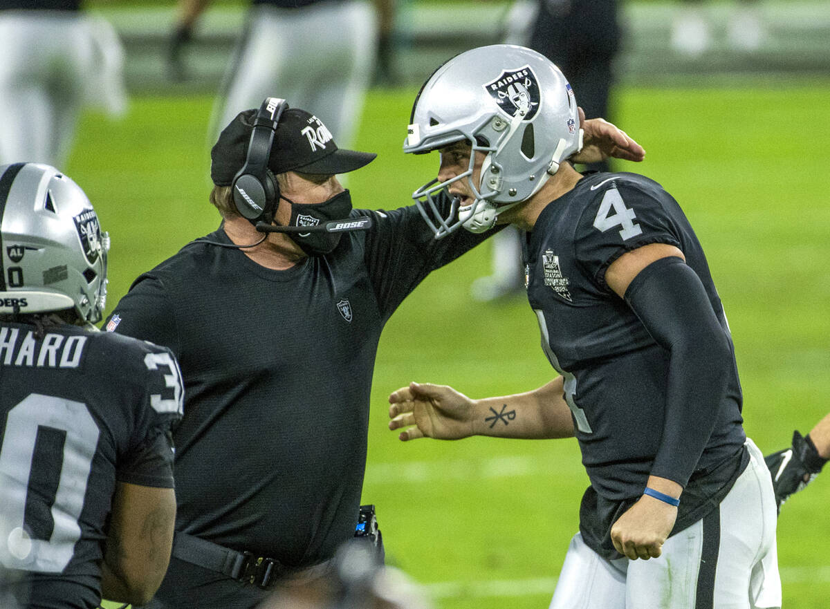 Raiders head coach Jon Gruden comes together on the sidelines with Raiders quarterback Derek Ca ...