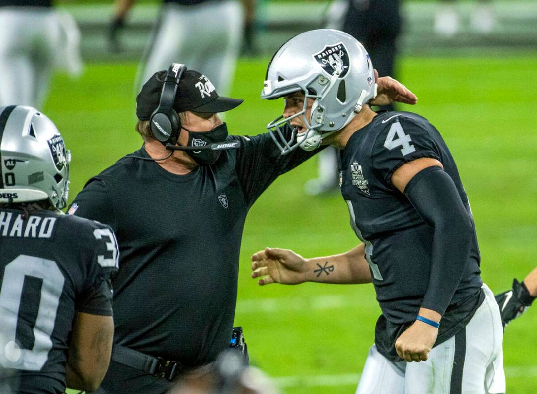 Raiders head coach Jon Gruden comes together on the sidelines with Raiders quarterback Derek Ca ...