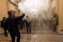 FILE - In this Jan. 6, 2021, file photo, smoke fills the walkway outside the Senate Chamber as ...