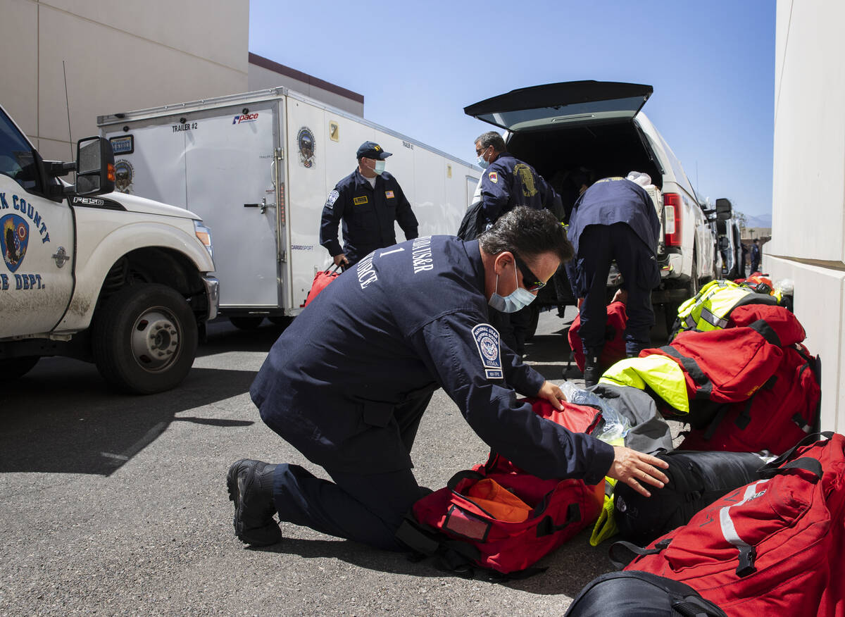 Members of the Nevada Task Force 1, including Tim Gardner, front, unload their equipments after ...