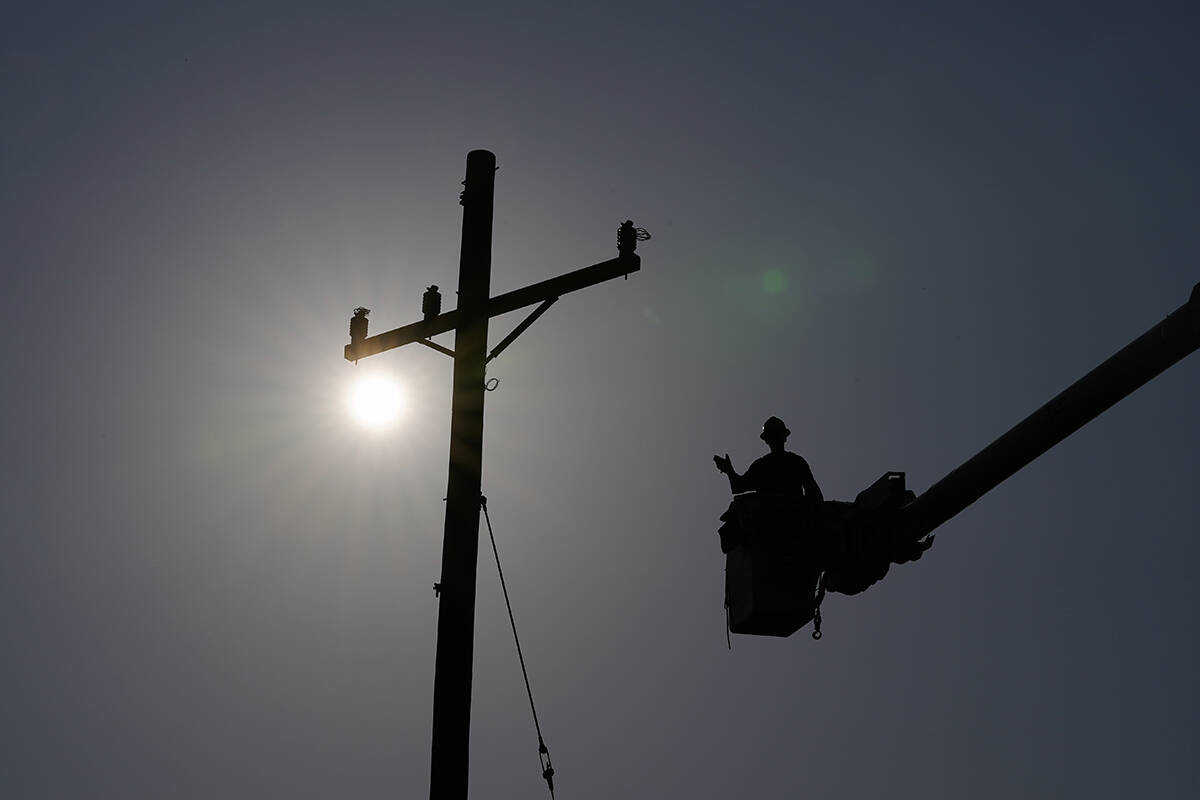 In the aftermath of Hurricane Ida, a lineman gestures as he works on a power pole, Sunday, Sept ...