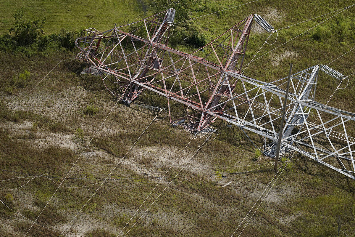A twisted tower that carried crucial electrical feeder lines to the New Orleans metro area lies ...