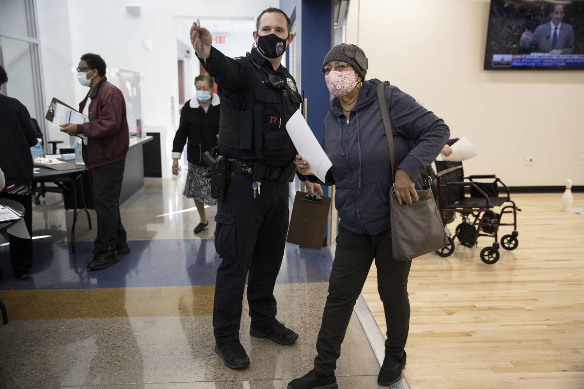 North Las Vegas Police officer Mazar directs Jacqueline Perkins-Denmark to the COVID-19 vaccina ...