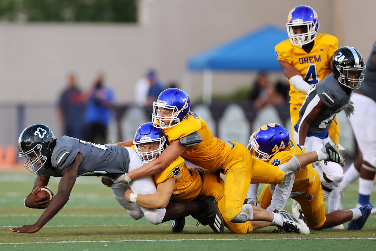 Desert Pines' Greg Burrell (23) is tackled by Orem's Tim Toa (44), Matthew Schroeder (24) and K ...