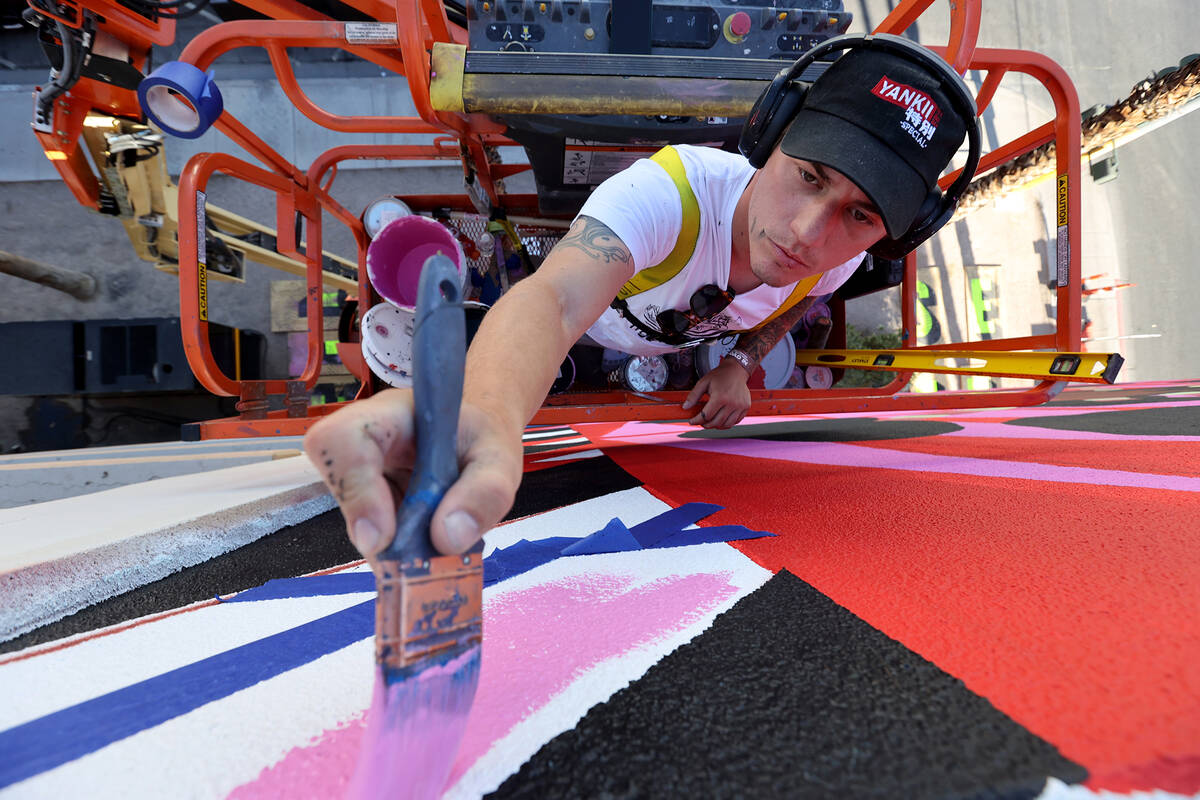 Sasha Rayevskiy, who goes by the name "Tigersasha," works on a mural by Criola titled "Black Gi ...