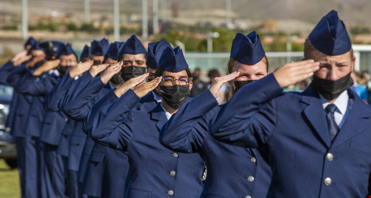 Air Force JROTC cadets salute as the colors are presented during a ceremony to honor the memory ...