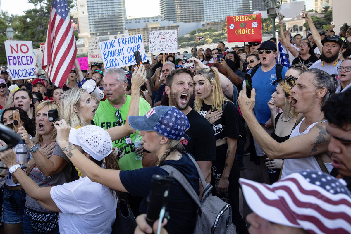 Anti-mask, anti-vaccination and freedom of choice protesters cheer after singing the national a ...