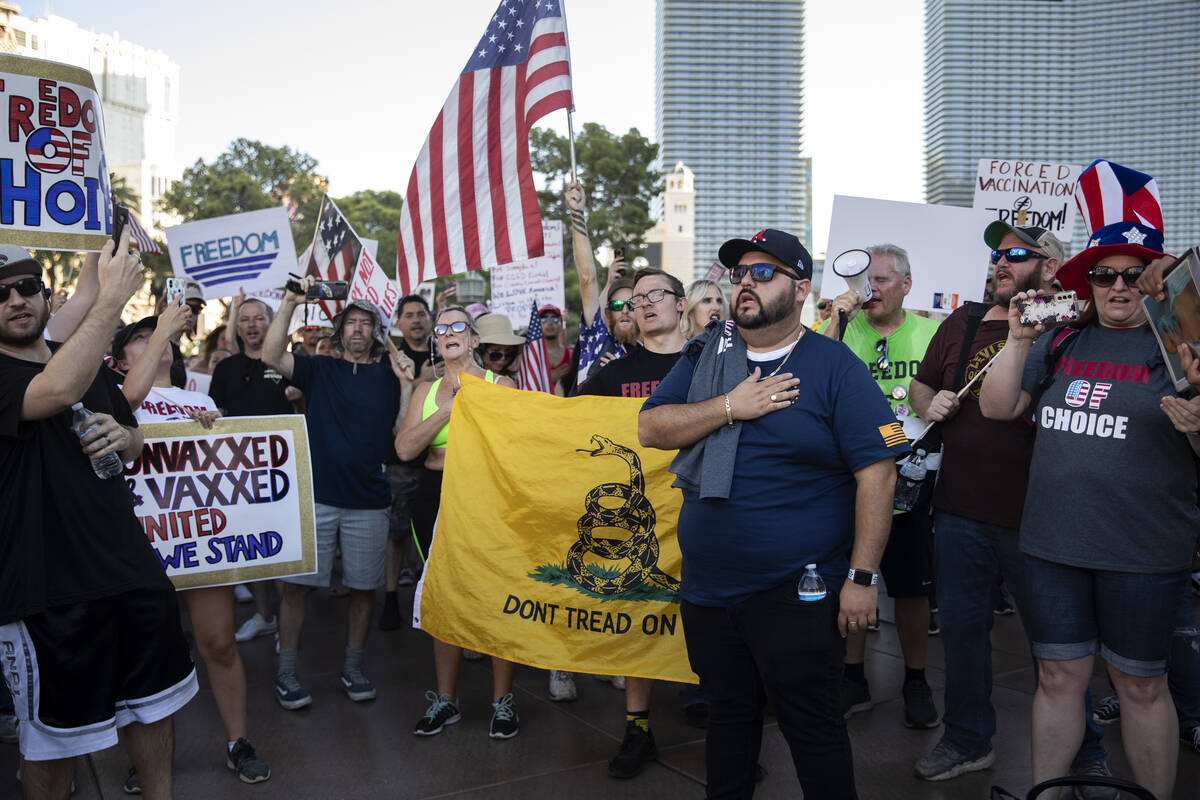 Attendees of an anti-mask, anti-vaccination and freedom of choice protest recite the Pledge of ...