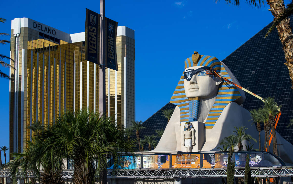 A team from Access Solutions hangs a Raiders eye patch on the Great Sphinx of Giza replica outs ...