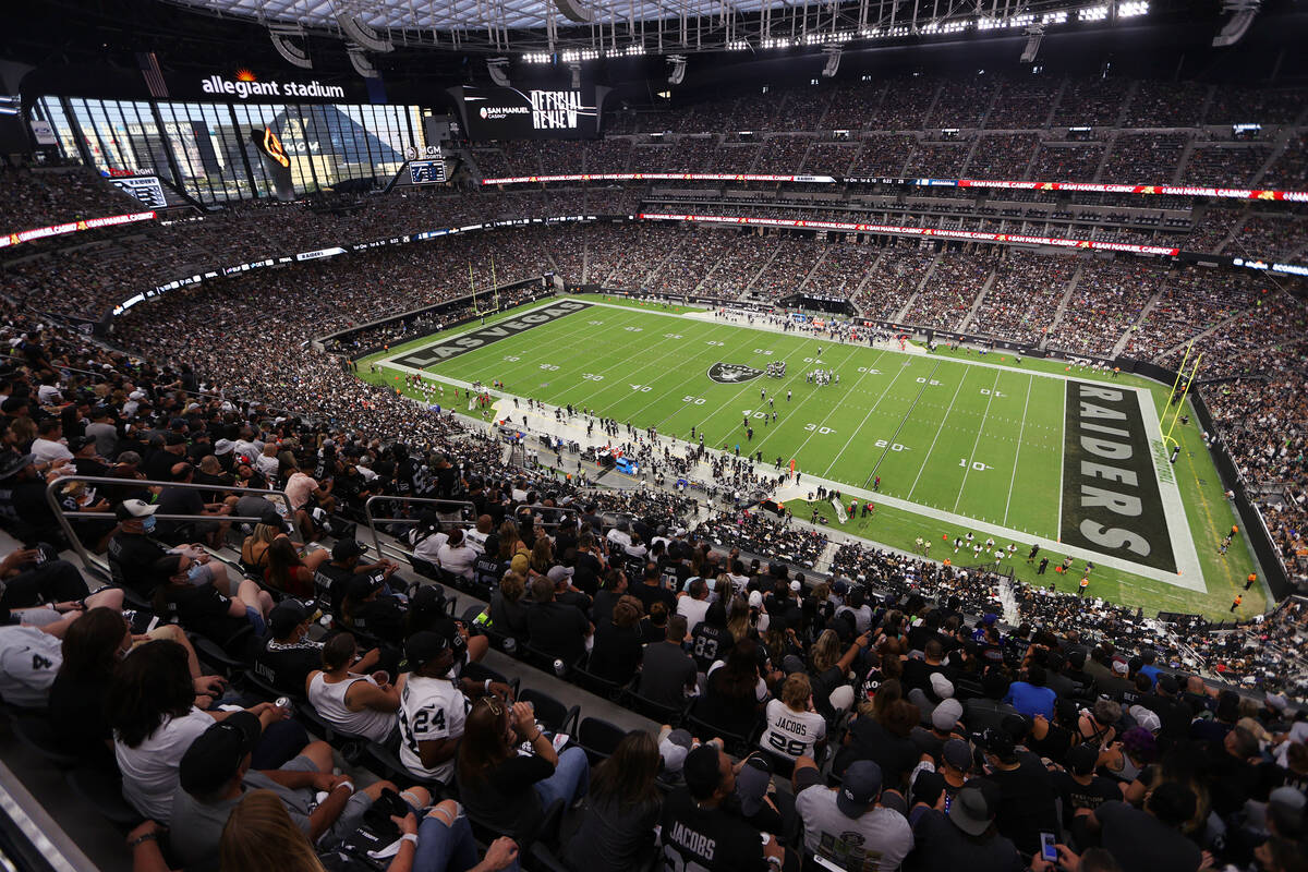 Fans listen to the singing of the national anthem before the start of a NFL preseason game betw ...