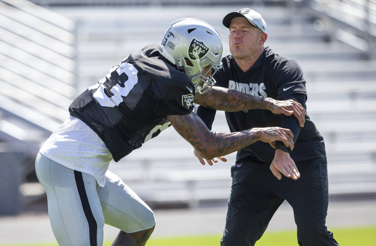Raiders tight end Darren Waller (83) pushes through tight ends coach Austin King during team pr ...