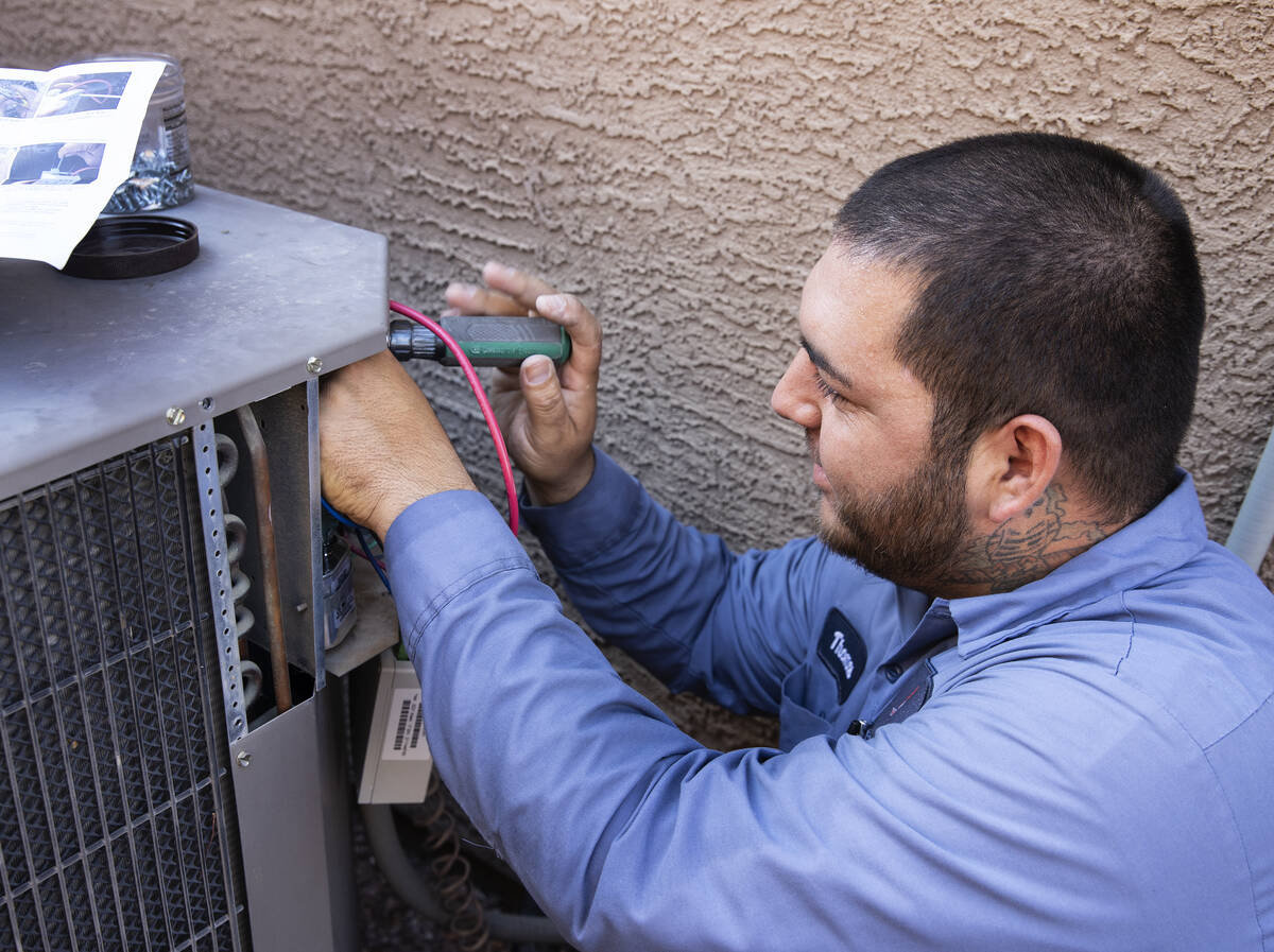 Windy City Air's technician Thomas Padron repairs an air conditioner at Vulcan St on Friday, Se ...