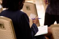 Jessica Dula reviews her vaccination card during a COVID-19 vaccine clinic at Resorts World Las ...