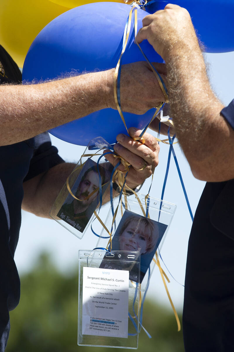 Retired New York Police Department officers untangle balloons with photographs of some police o ...