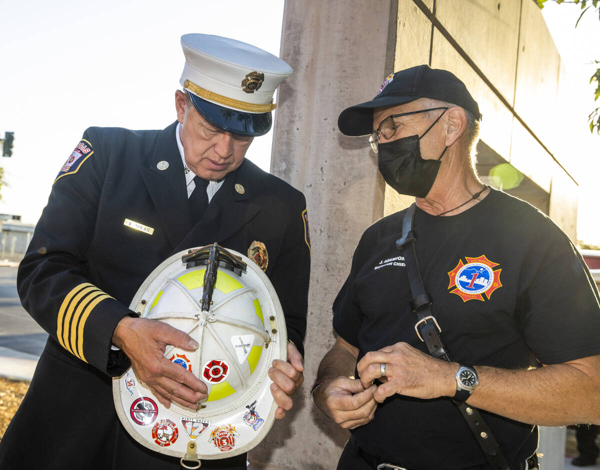 City of Las Vegas Fire Marshal Robert Nolan, left, looks over an old fire helmet from former An ...