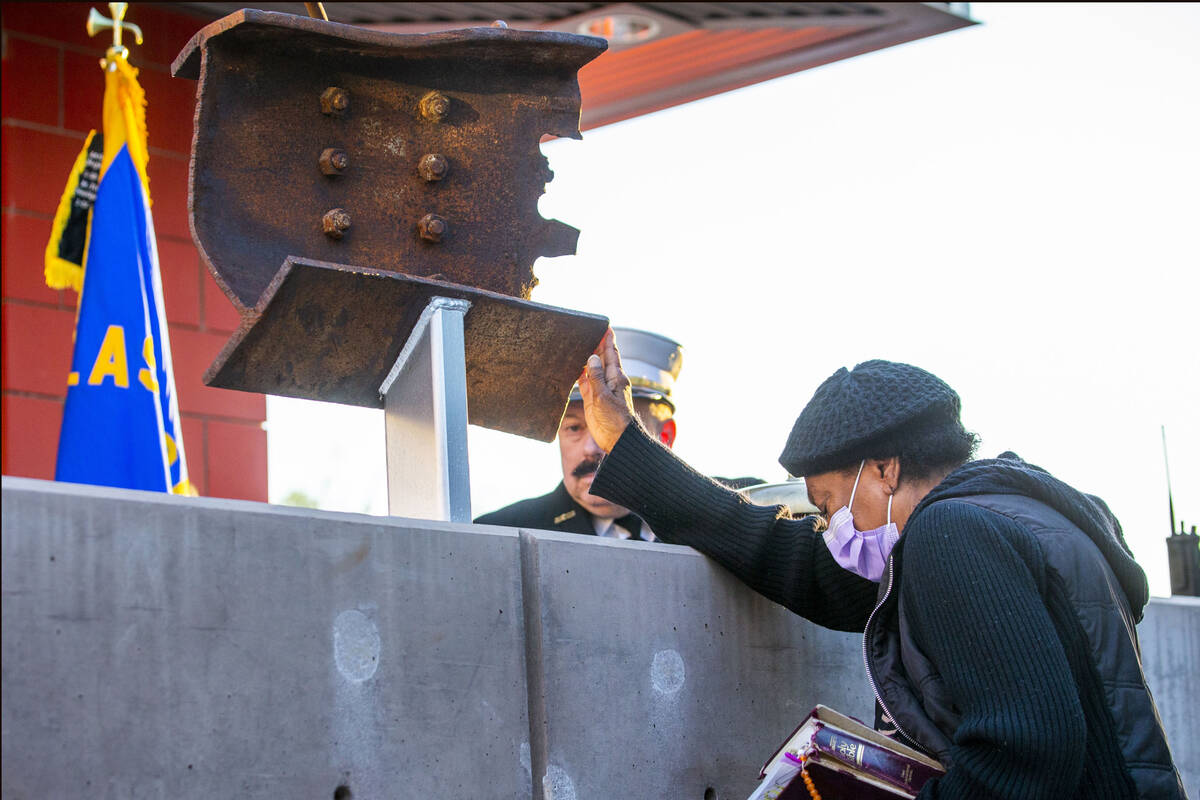 Carolann Roberts of Henderson prays while touching a piece of World Trade Tower steel on displa ...