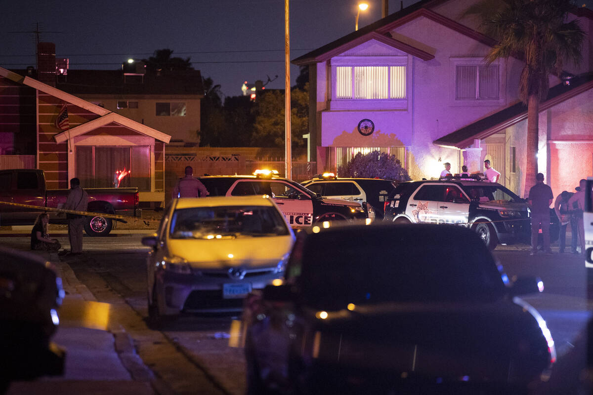 Las Vegas police officers investigate the scene of homicide on Montcliff Avenue in Spring Valle ...