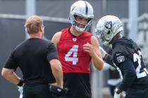 Raiders quarterback Derek Carr (4) meets with head coach Jon Gruden, left, and Raiders running ...
