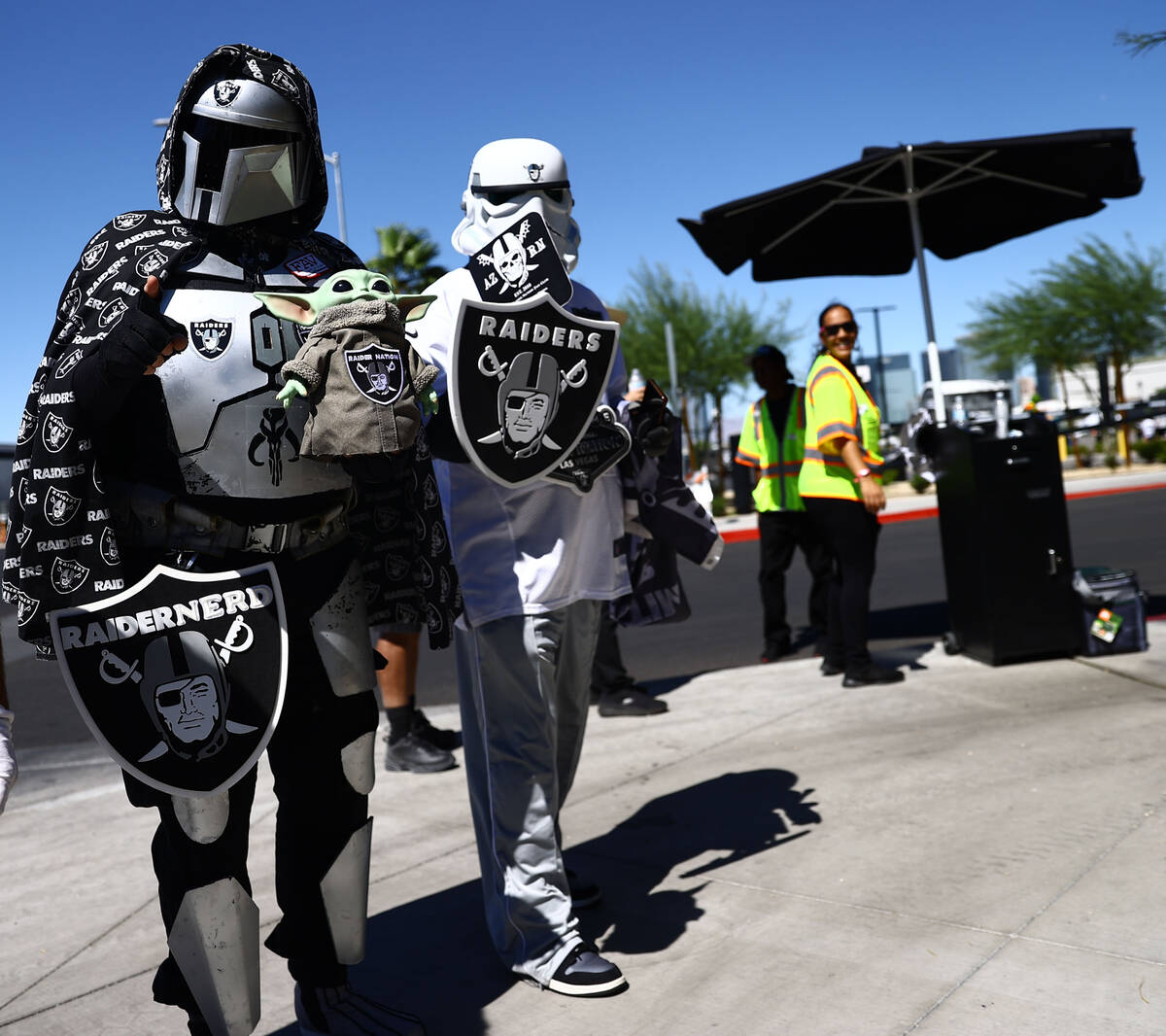 Fans wearing costumes walk around before an NFL football game between the Raiders and the Balti ...