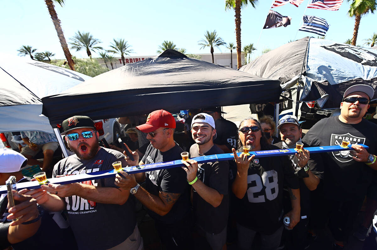 Fans are ready to drink while tailgating before an NFL football game between the Raiders and th ...