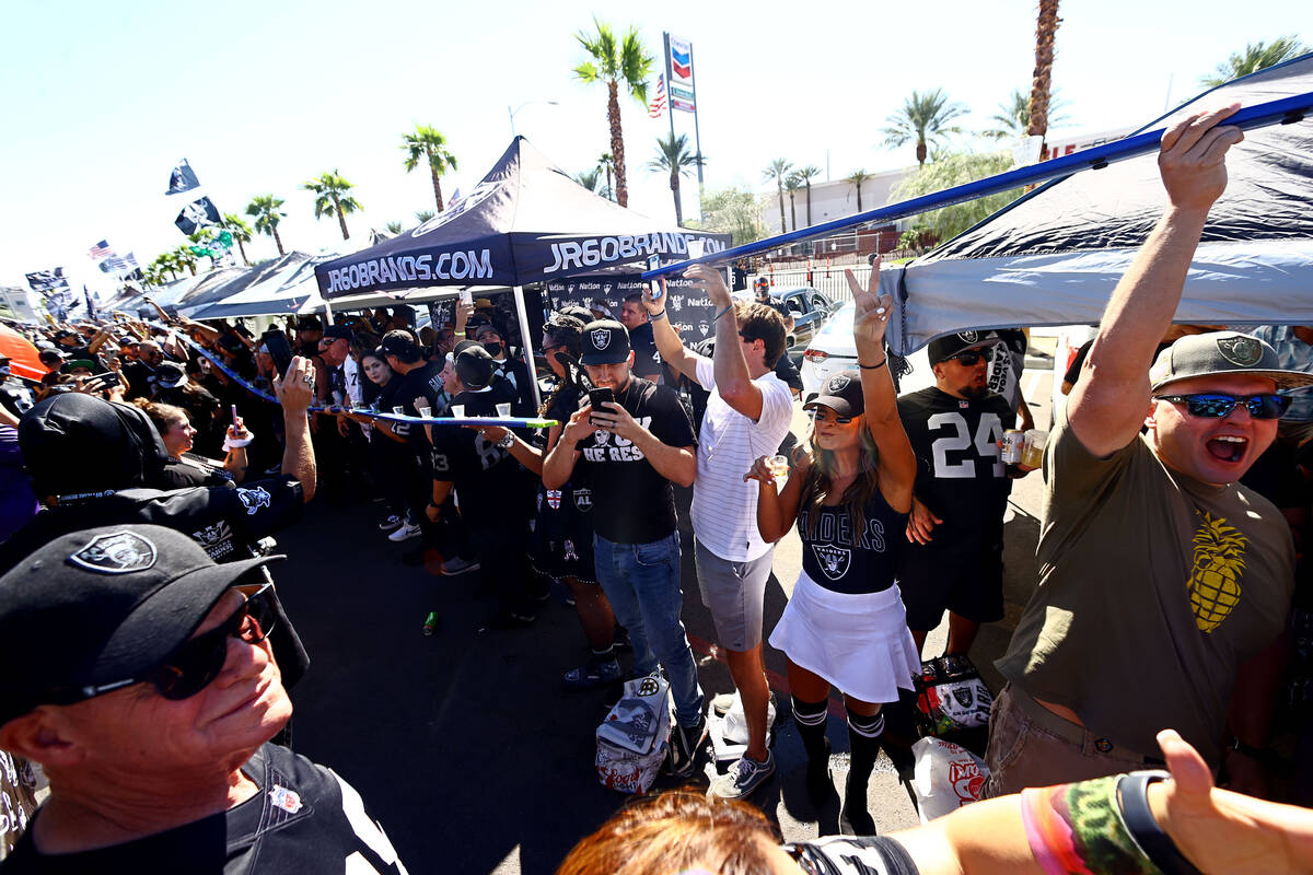 Fans spend time tailgating before an NFL football game between the Raiders and the Baltimore Ra ...