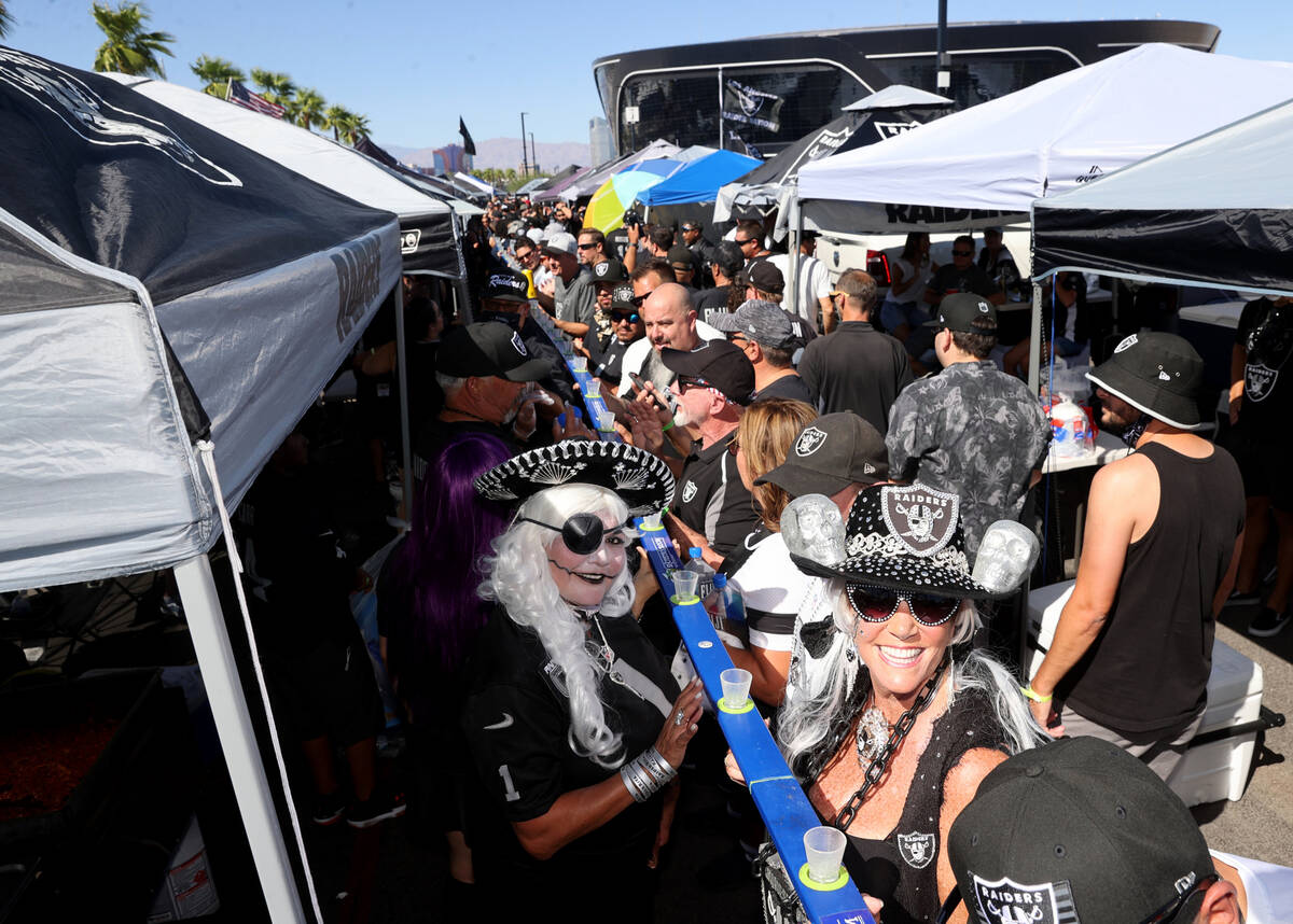 Fans, including Jon "Rhinestone Raider" Adair, right and "Raider Rita," pre ...