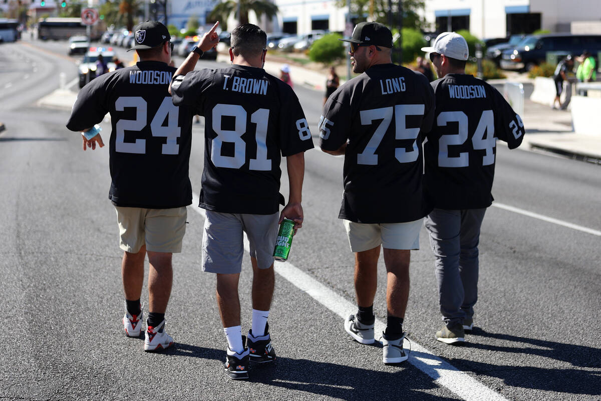 Fans cross the Hacienda Avenue bridge toward Allegiant Stadium for a game between the Raiders a ...