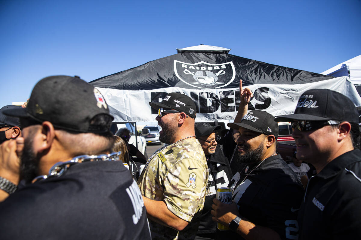 Football fans tailgate before an NFL game between the Raiders and the Baltimore Ravens at Alleg ...