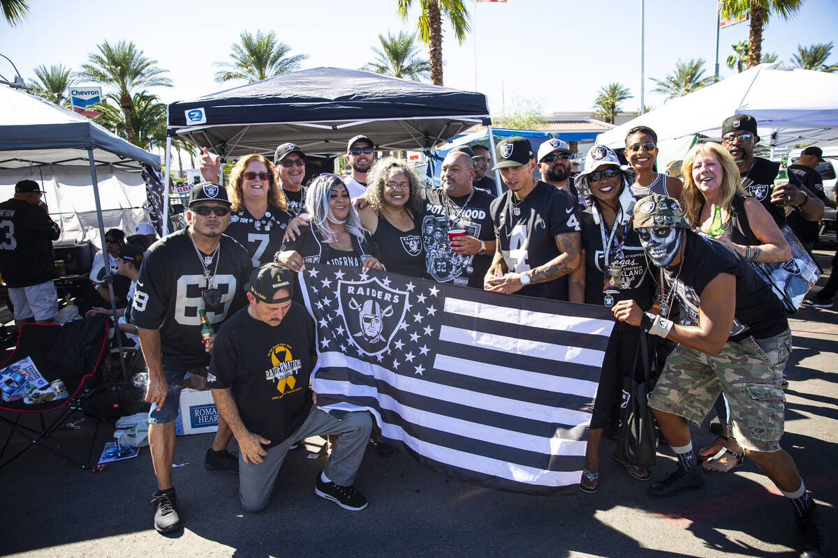 Football fans pose for picture while tailgating before an NFL game between the Raiders and the ...