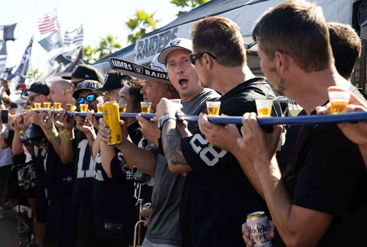 Tailgaters lineup for a drink before an NFL football game between the Raiders and Baltimore Rav ...