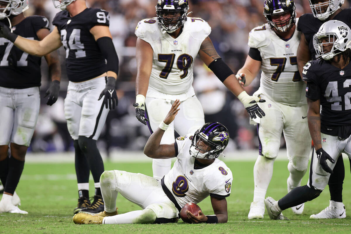 Baltimore Ravens quarterback Lamar Jackson (8) gestures to the referees after a play in the fou ...