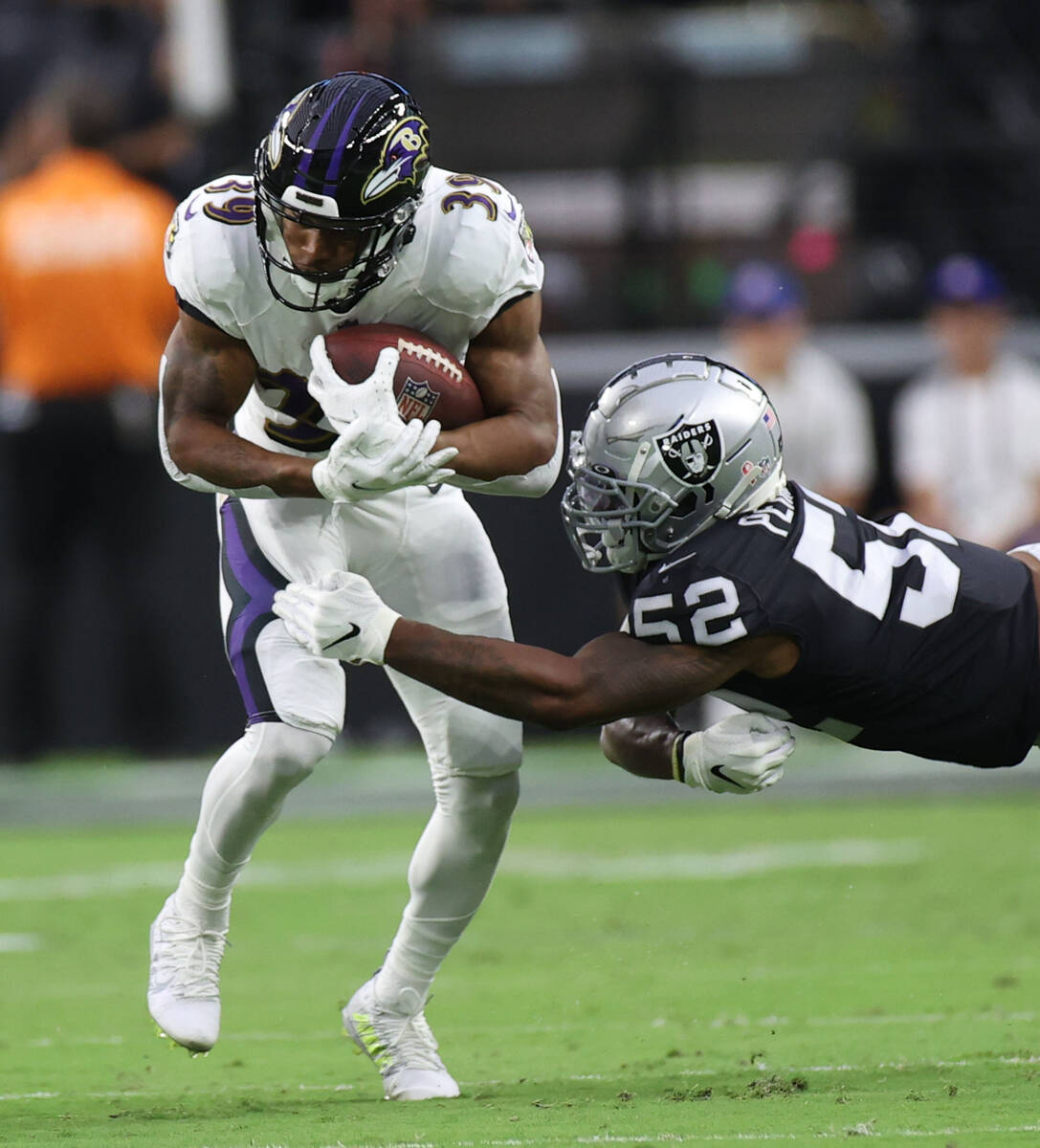 Baltimore Ravens running back Trenton Cannon (39) keeps a ball away from Raiders linebacker Den ...