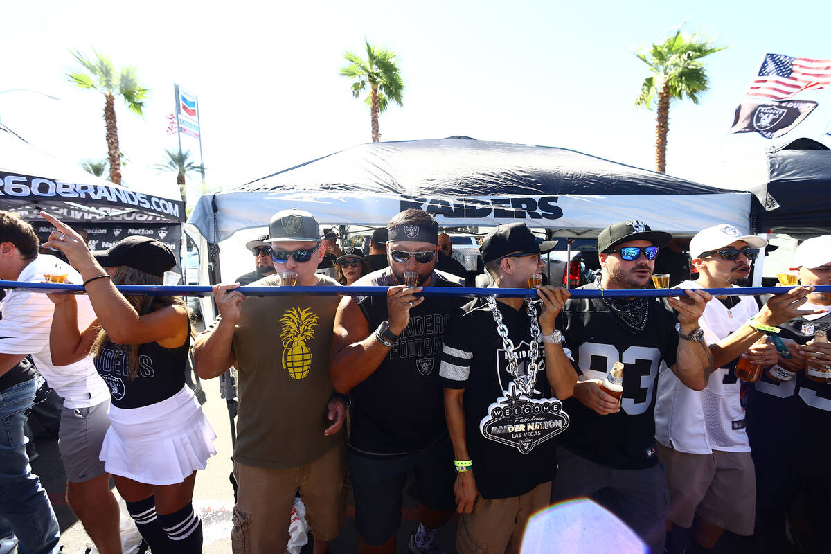 Raiders fans tailgate outside of Allegiant Stadium ahead of the team's game against the Baltimo ...