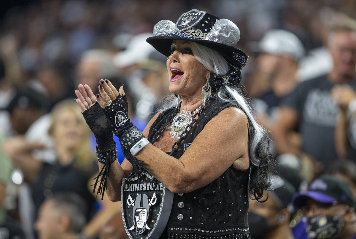 A Raiders fan cheers during the first quarter of an NFL football game against the Baltimore Rav ...