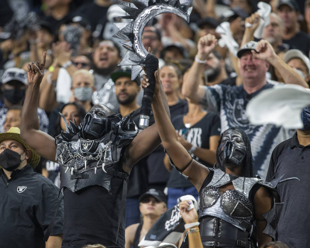 A pair of costumed Raiders fans rally the crowd during the second quarter of an NFL football ga ...