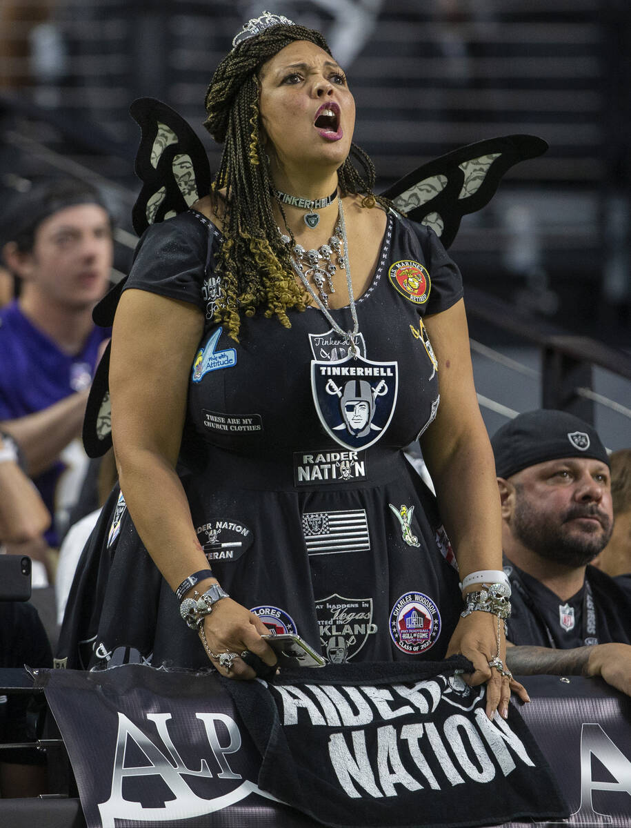 A Raiders fan cheers during the first quarter of an NFL football game against the Baltimore Rav ...