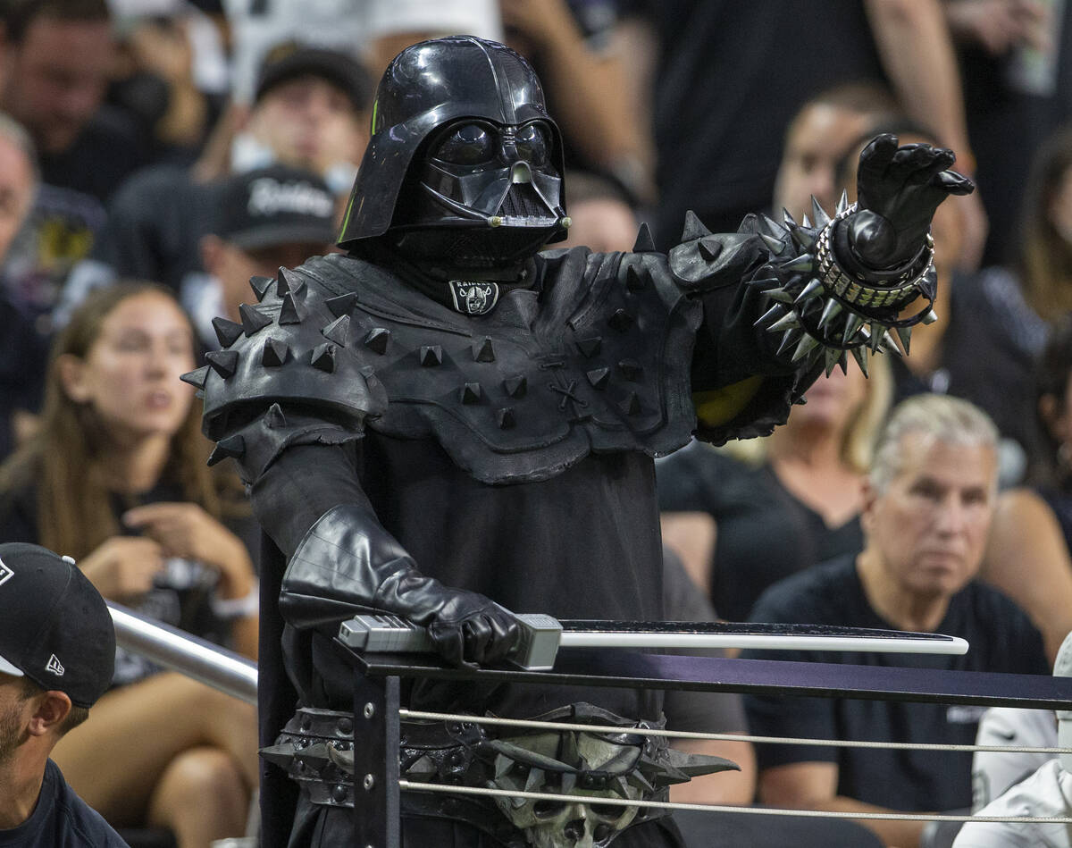 A Raiders fan dressed as Darth Vader looks on during the first quarter of an NFL football game ...
