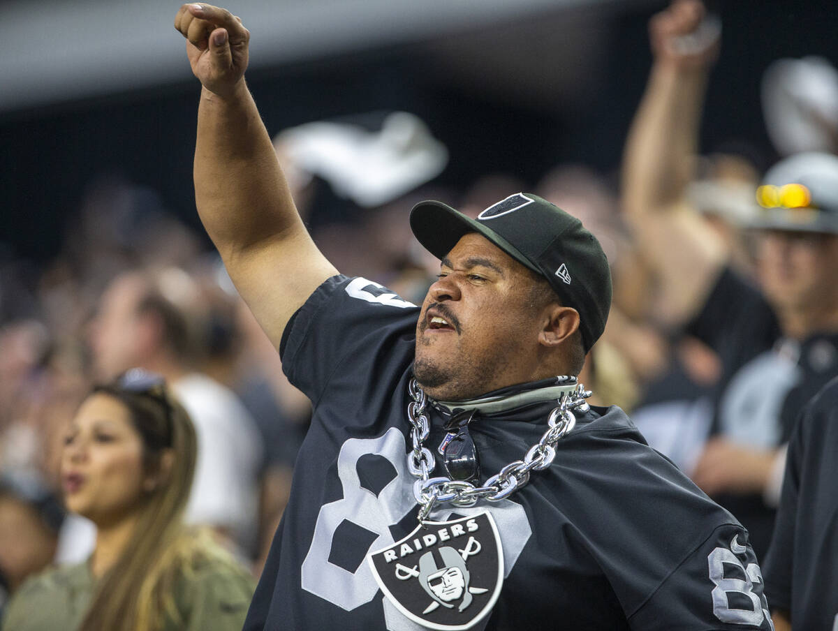 A Raiders fan cheers during the first quarter of an NFL football game against the Baltimore Rav ...