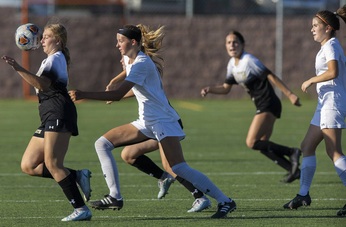 Faith Lutheran’s Taylor Folk (26) and Arbor View’s Madison Little (14) attempt to chase dow ...