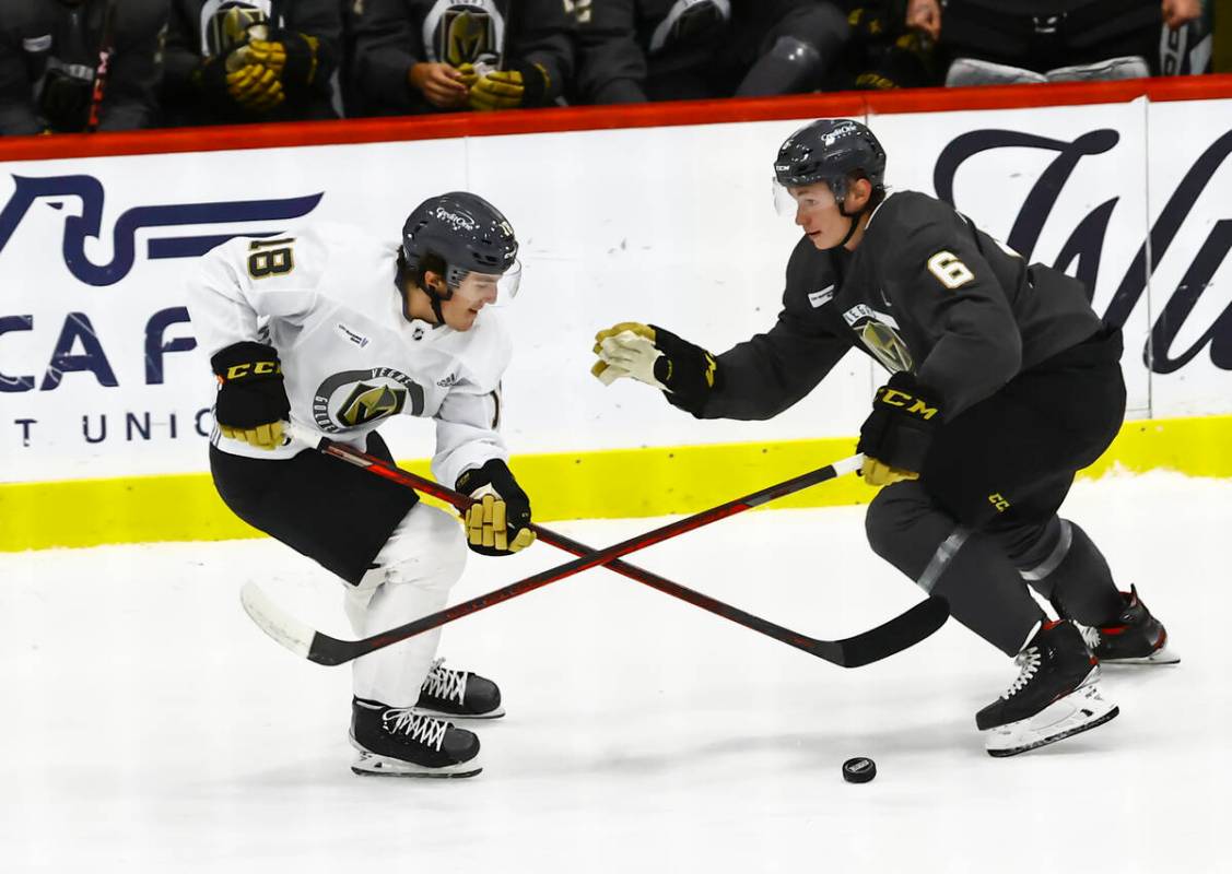 Golden Knights' Peyton Krebs (18) looks to get the puck around Kaedan Korczak (6) during a scri ...