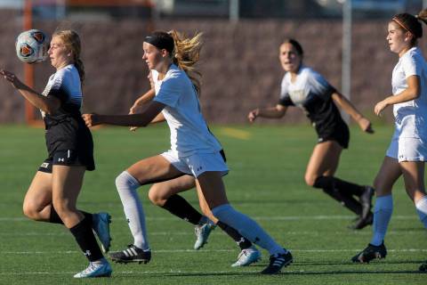 Faith Lutheran’s Taylor Folk (26) and Arbor View’s Madison Little (14) attempt to ...
