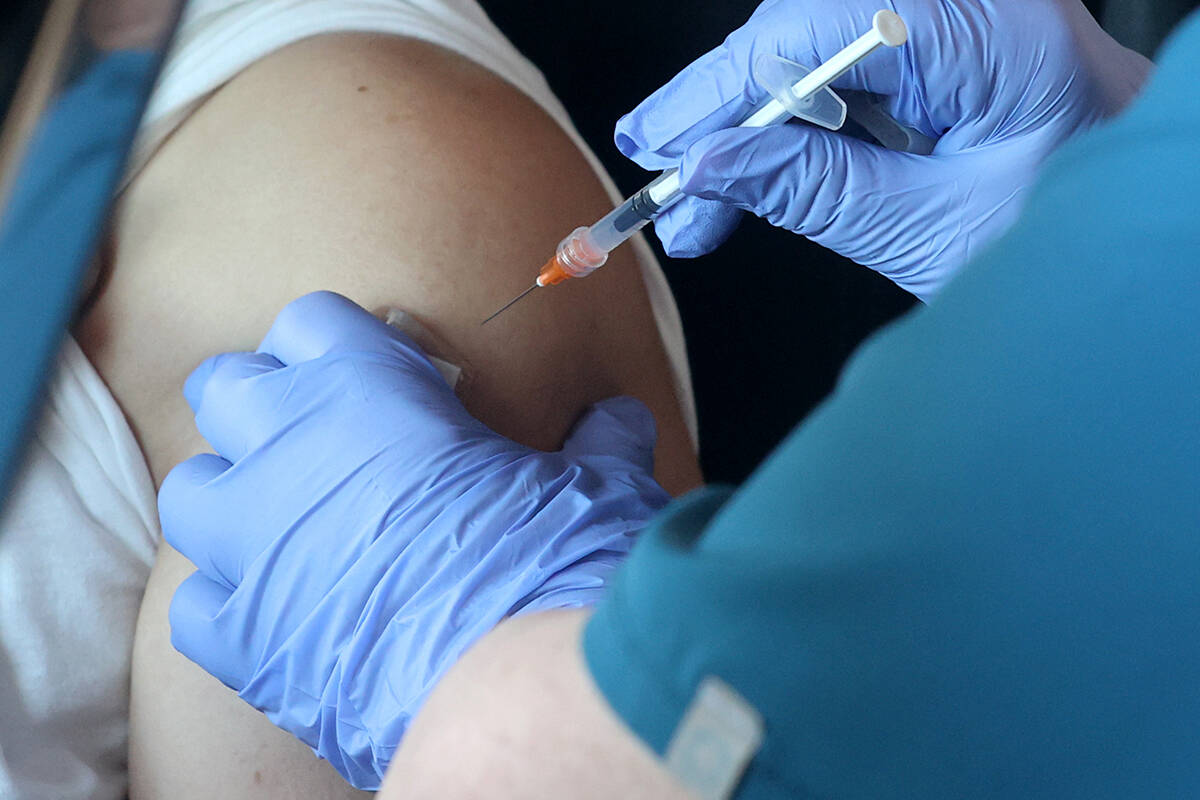 Teresa Woods gives a shot during a drive-thru COVID-19 vaccine clinic in the Bronze Lot at the ...