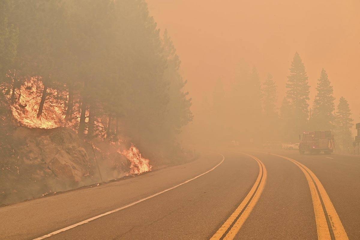 The Caldor Fire burns on both sides of Highway 50 about 10 miles east of Kyburz, Calif., on Thu ...