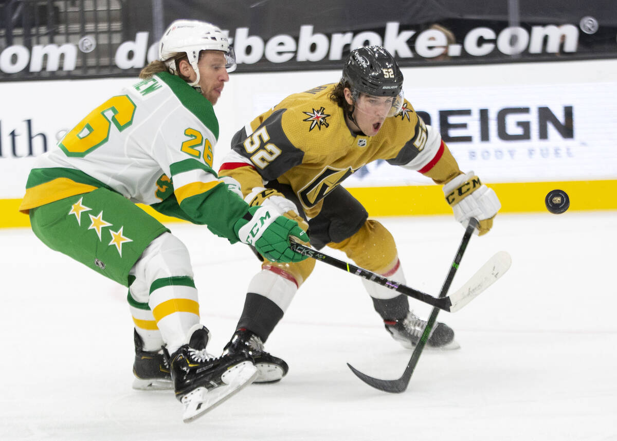 Wild center Gerald Mayhew (26) and Golden Knights defenseman Dylan Coghlan (52) compete for the ...