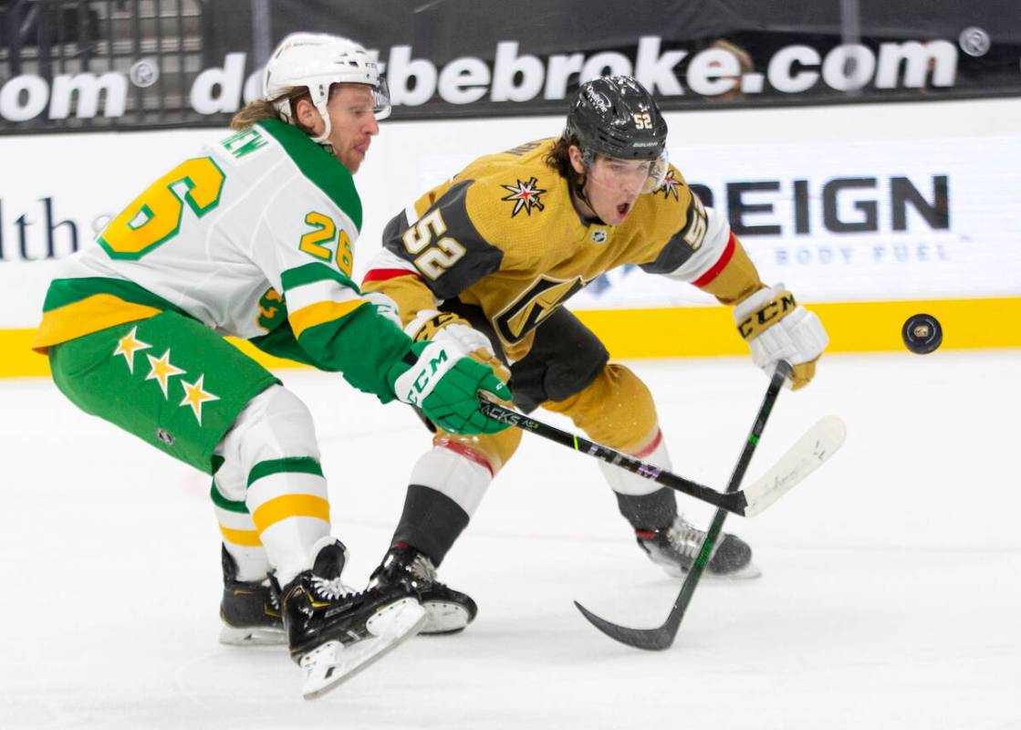 Wild center Gerald Mayhew (26) and Golden Knights defenseman Dylan Coghlan (52) compete for the ...
